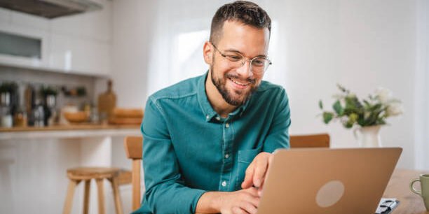 man adult caucasian WITH BEARD AND EYEGLASSES work on laptop at home